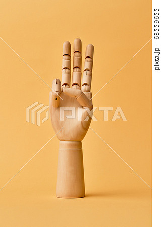 Wooden human hand with three fingers raised up 63559655
