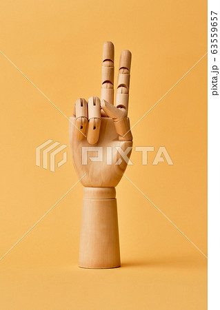 Wooden human hand with two fingers raised up Wooden human hand with two fingers raised up 63559657