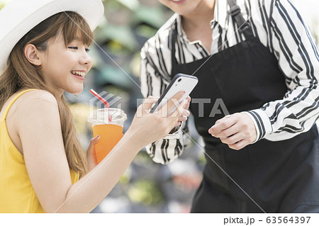 カフェでくつろぐリゾートファッションの女性 カフェでくつろぐリゾートファッションの女性 63564397