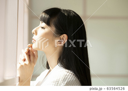 窓辺でリラックスする女性 窓辺でリラックスする女性 63564526