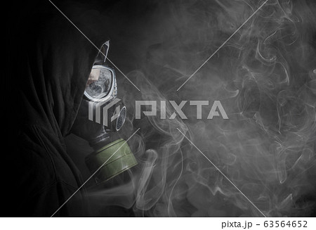 Man in a gas mask in the smoke 63564652