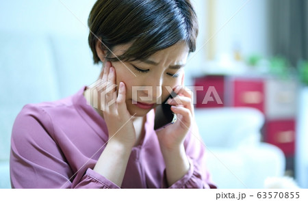 スマホとネガティブな女性イメージ 63570855