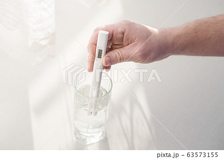 Man determines level of total dissolved solids or TDS in drinking water at home. Device shows 200 ppm of contaminant level which is considered the typical value in the scale of water TDS. Health care Man determines level of total dissolved solids or TDS in drinking water at home. Device shows 200 ppm of contaminant level which is considered the typical value in the scale of water TDS. Health care 63573155