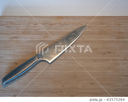 A large kitchen knife on a cutting board A large kitchen knife on a cutting board 63575264