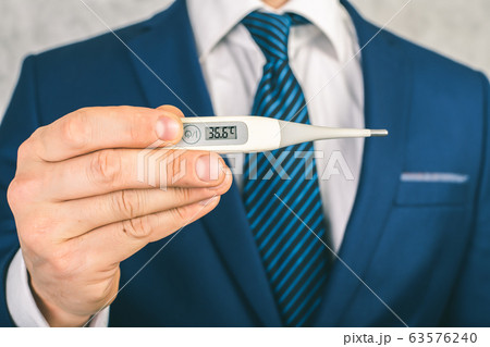 A man in a suit and tie holds in his hands an 63576240