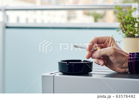man in pajamas smoking in the balcony 63576492