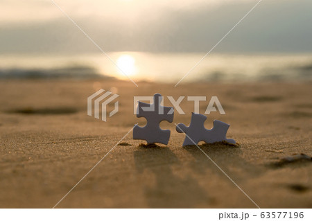 Jigsaw on the beach sand matching puzzle pieces together Jigsaw on the beach sand matching puzzle pieces together 63577196