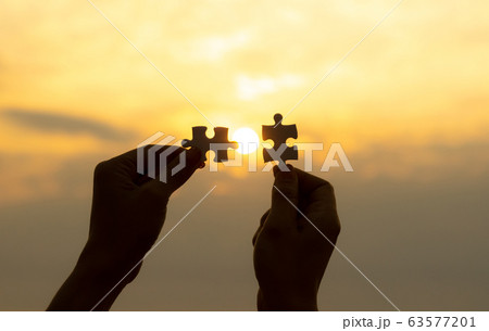 Hands two matching puzzle pieces together sun to complete Hands two matching puzzle pieces together sun to complete 63577201