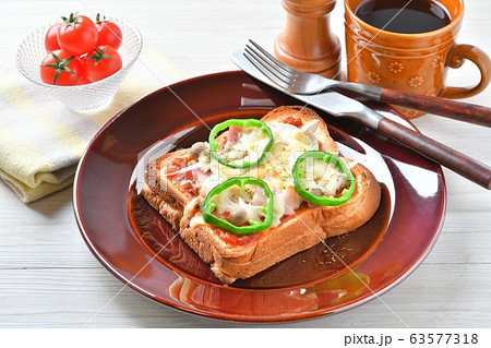 朝食のピザトースト 厚切り食パンに ピザソース ベーコン 新玉ネギ シメジ チーズ ピーマンを載せ の写真素材