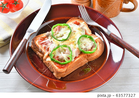 朝食のピザトースト 厚切り食パンに ピザソース ベーコン 新玉ネギ シメジ チーズ ピーマンを載せ の写真素材