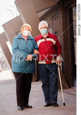An elderly couple of people in masks 63578268