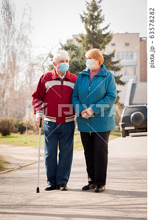 An elderly couple walk along the street during 63578282