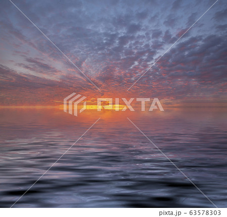 View of sunset into the ocean with twilight sky. Fiery orange sunset sky. Beautiful sky 63578303