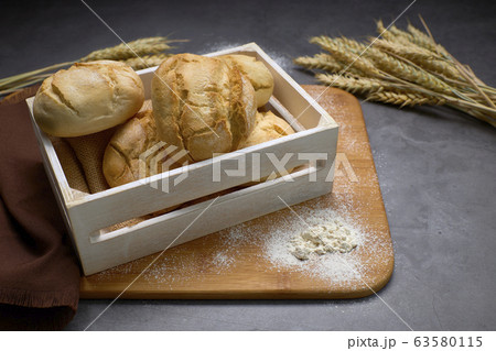 Delicious breads next to ears of wheat on a wooden 63580115
