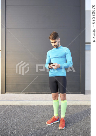 sportsman looking at the internet app on his sportsman looking at the internet app on his 63580670