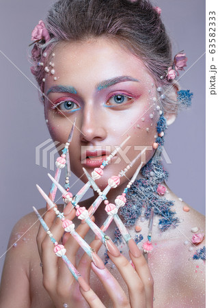 Beautiful girl in the image of a sweet fairy with art make-up and with long design nails. Creative manicure. 63582333