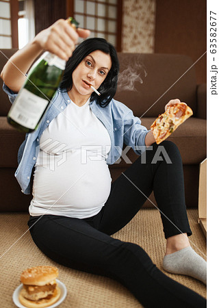 Pregnant woman smoking and drinks alcohol 63582677