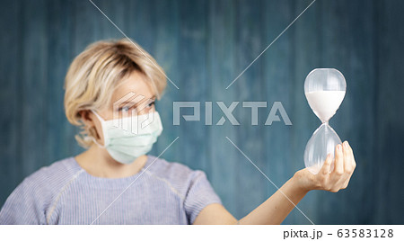 young woman in medical face protection mask indoors on blue background 63583128