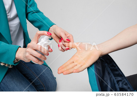 Woman applying antiseptic on boy's hand. COVID-19 63584170