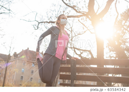 Woman during coronavirus crises exercising outdoors 63584342