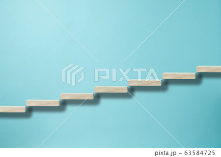 水色背景に上昇イメージで右肩上がりに並べられた積み木 63584725