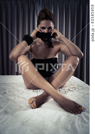 Low key portrait of submissive woman in handcuffs Low key portrait of submissive woman in handcuffs 63585959