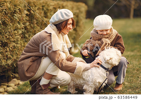 Mother with daughter walks with a dog 63586449