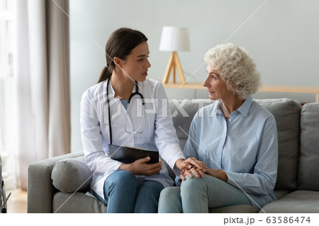 Young woman doctor visit consult mature old lady 63586474