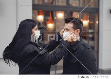 People in a masks stands on the street 63586678