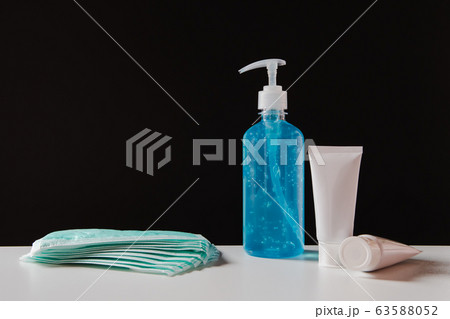 Sanitizer gel bottle and masks to prevent viruses. 63588052