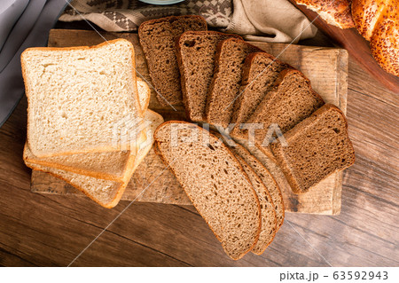 Tasty bagels with slices of bread and bowl of flour Tasty bagels with slices of bread and bowl of flour 63592943
