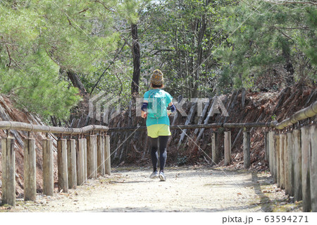 公園を走る女性ランナー 63594271