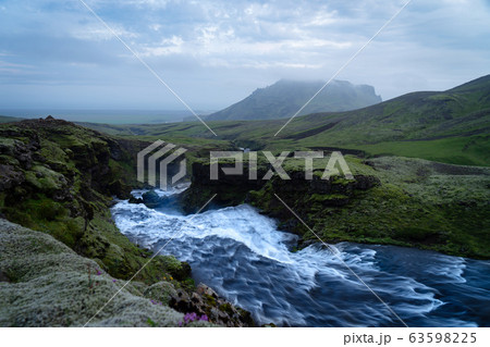 Beautiful smooth waterfall in Iceland during evening dusk 63598225