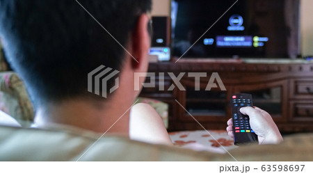 Man watching tv with hands on the remote control Man watching tv with hands on the remote control 63598697