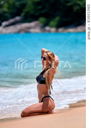 Model in black swimsuit posing at the beach Model in black swimsuit posing at the beach 63601060