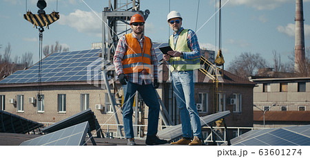 Engineer and technician discussing between solar panels 63601274