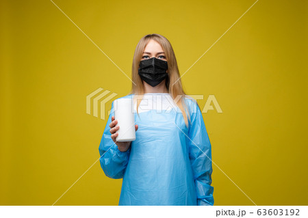 Young beautiful girl in a disposable medical gown 63603192
