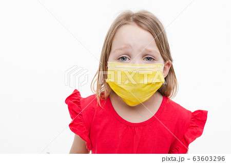 Portrait of little girl with yellow medical mask 63603296