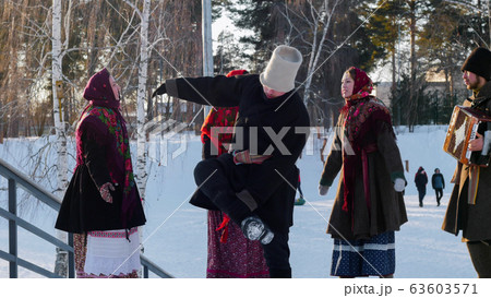 Russian folklore - young people in felt boots dancing outdoors at winter time in the park Russian folklore - young people in felt boots dancing outdoors at winter time in the park 63603571