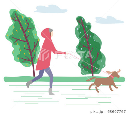Woman Walking Dog on Leash in Windy Autumn Day 63607767