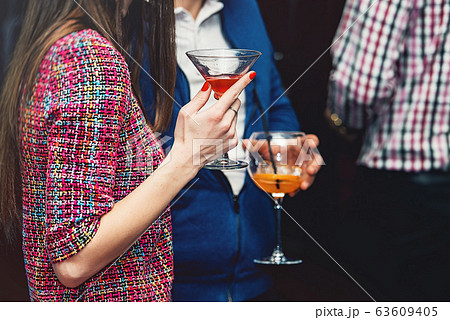 young woman holds drink in a bar young woman holds drink in a bar 63609405