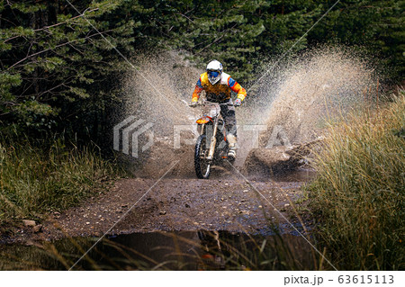 enduro racer riding on water with splashes 63615113