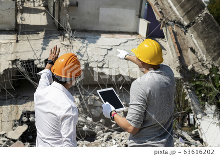 Demolition control supervisor and foreman discussing on demolish building. 63616202