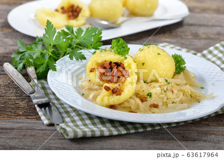 Handmade potato dumplings stuffed with greaves served on warm cabbage salad, an Austrian and Bavarian specialty Handmade potato dumplings stuffed with greaves served on warm cabbage salad, an Austrian and Bavarian specialty 63617964