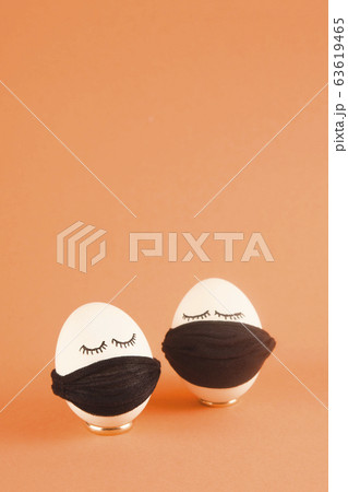 White Easter eggs with eyes in black medical masks 63619465