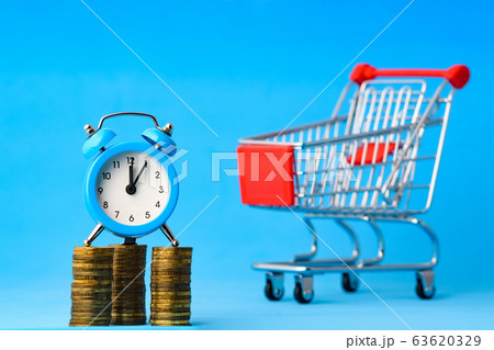 A clock stands on a stack of coins, in the A clock stands on a stack of coins, in the 63620329
