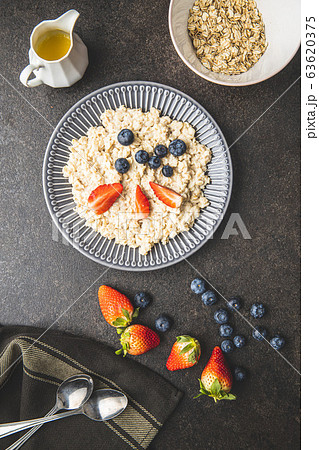 Plate of oatmeal porridge with strawberries and 63620375