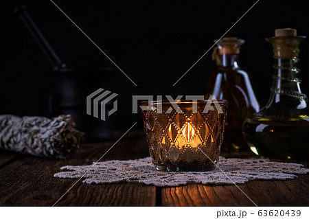 Esoteric still life with burning candle, green 63620439