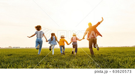 Anonymous happy family running back in field in Anonymous happy family running back in field in 63620573