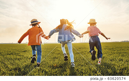 Anonymous happy children running backin field 63620574